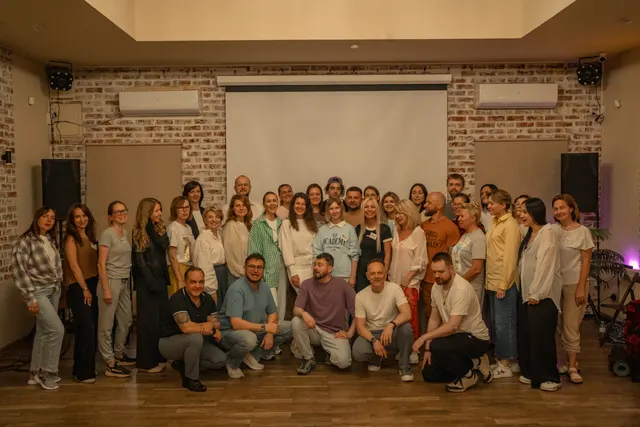 Большая групповая фотография на траве, атмосфера ретрита