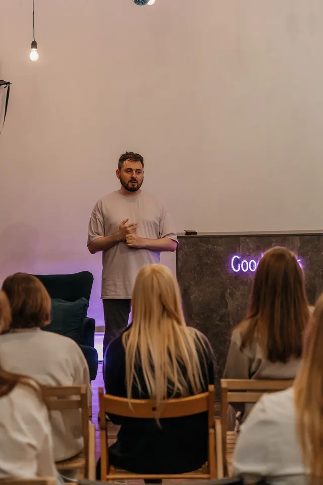 Спикер перед залом на фоне баннера